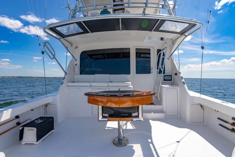 Slide: The Image of 2006 Viking 56 Convertible yacht deck with fishing setup, ocean view, and clear sky. - 44