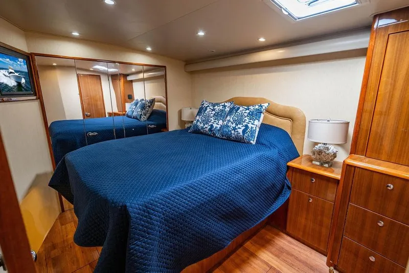 Slide: The Image of Luxurious bedroom interior of 2006 Viking 56 Convertible yacht with blue bedding and wooden furnishings. - 24