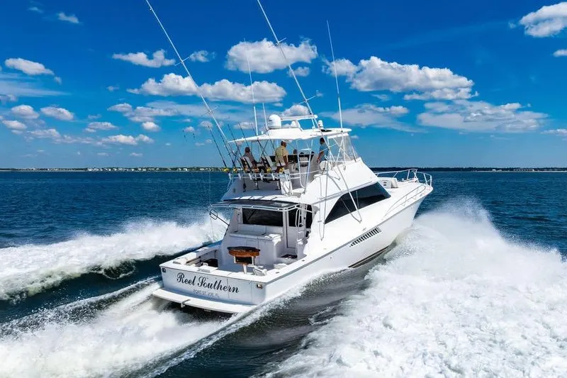 Slide: The Image of 2006 Viking 56 Convertible yacht cruising on open water under a clear blue sky. - 3