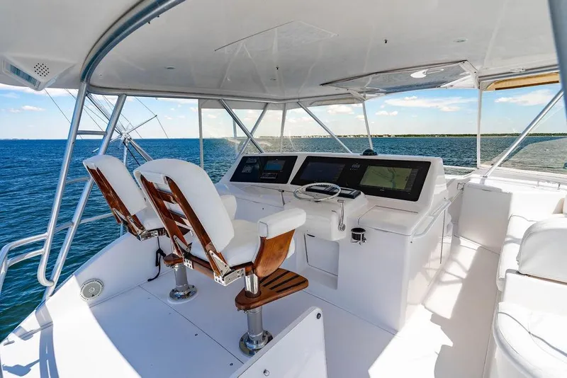 Slide: The Image of 2006 Viking 56 Convertible yacht helm with ocean view, featuring modern navigation equipment. - 32