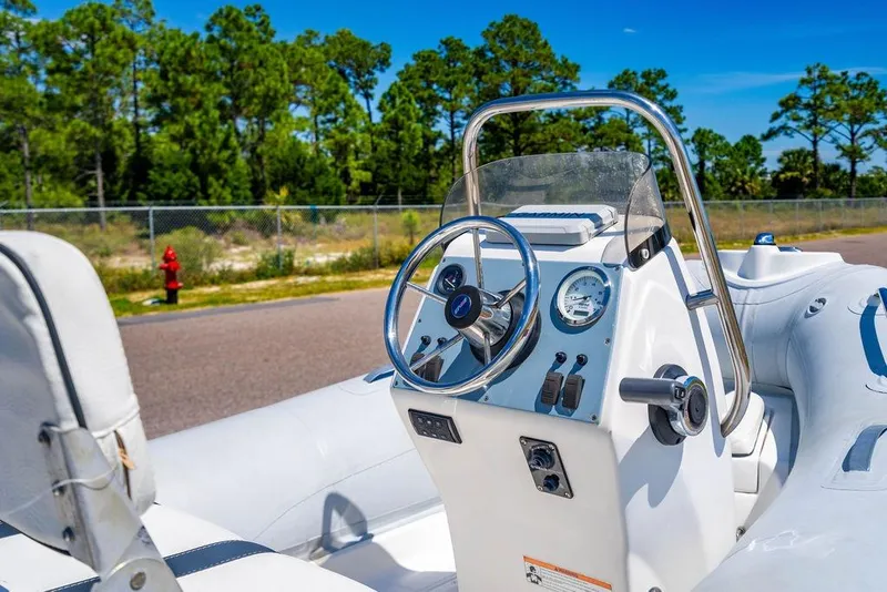 Slide: The Image of Steering console of a 2006 Viking 56 Convertible boat, outdoors with trees in background. - 58