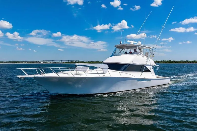Slide: The Image of 2006 Viking 56 Convertible yacht cruising on open water under a clear blue sky. - 11