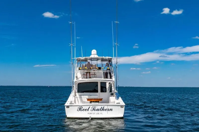 Slide: The Image of 2006 Viking 56 Convertible boat on open water under clear blue sky. - 2