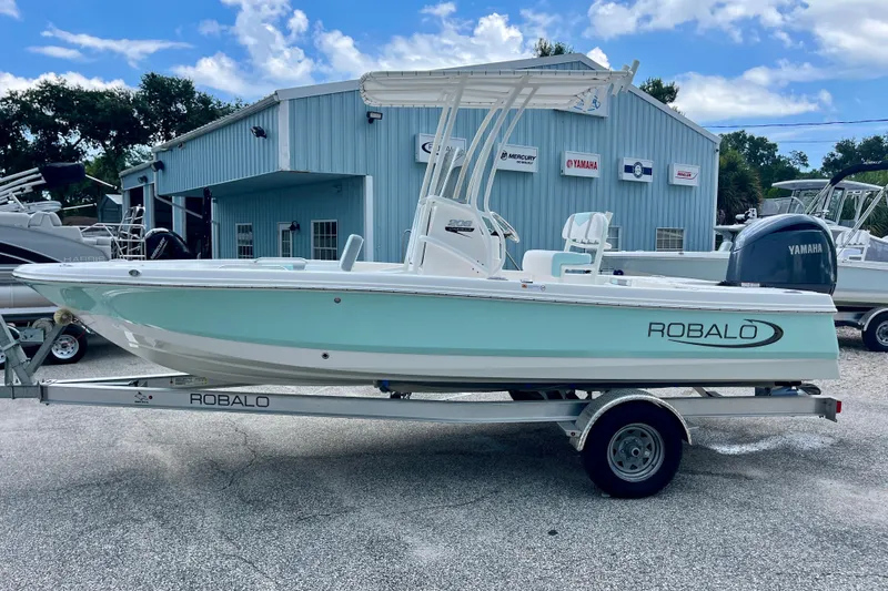 Slide: The Image of 2024 Robalo 206 Cayman boat on trailer, parked outside a marine dealership. - 5