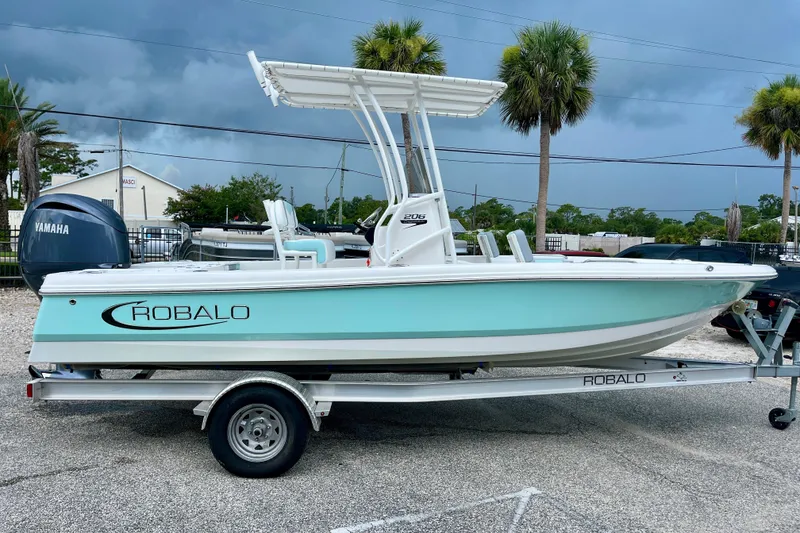 The Image of 2024 Robalo 206 Cayman boat on trailer, featuring sleek design and Yamaha engine. - 1