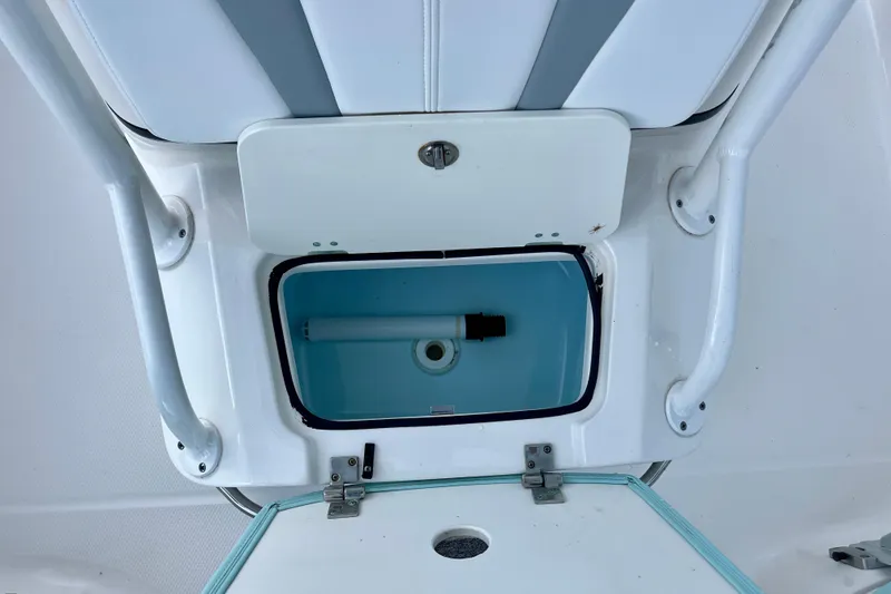Slide: The Image of 2024 Robalo 206 Cayman boat storage compartment with open hatch and blue interior. - 19