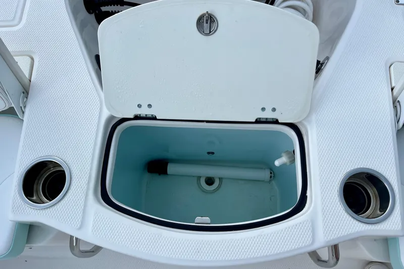 Slide: The Image of Open storage compartment on 2024 Robalo 206 Cayman boat deck, featuring cup holders. - 16