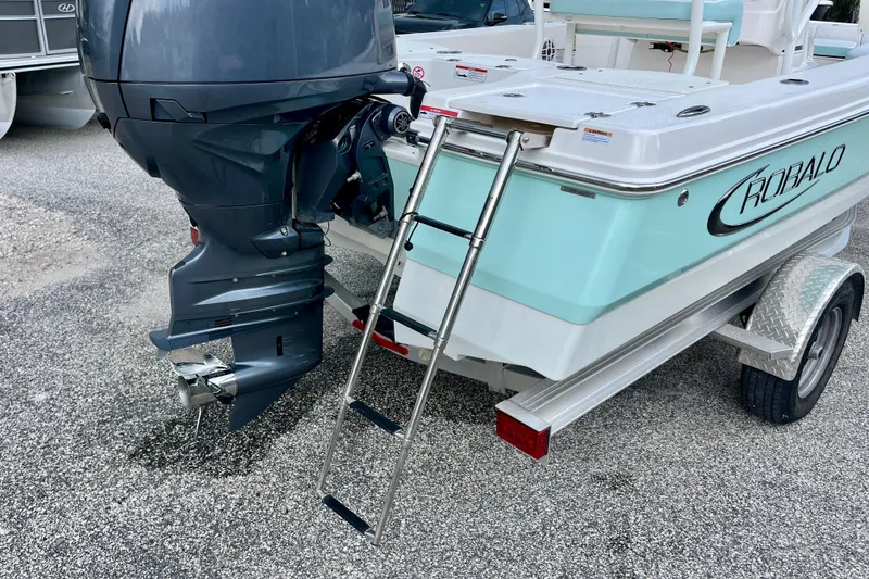 Slide: The Image of 2024 Robalo 206 Cayman boat with outboard motor and ladder on trailer. - 11