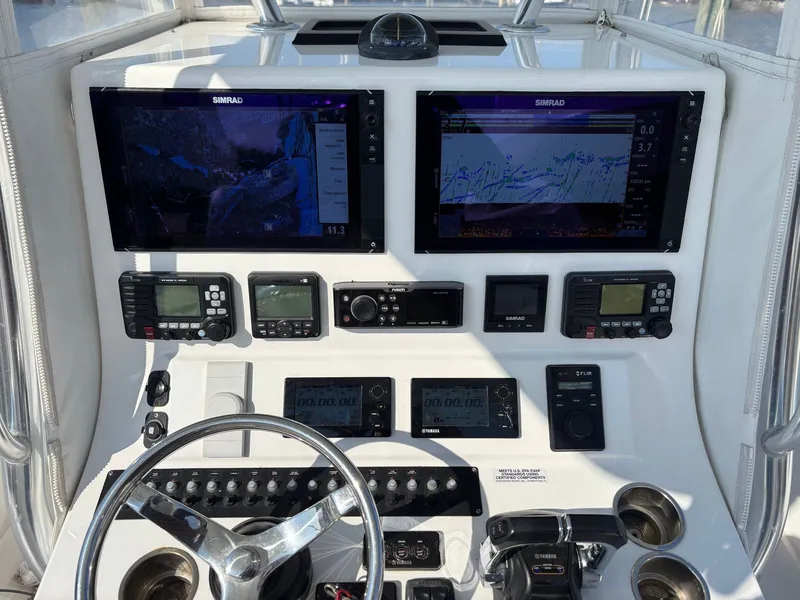 Slide: The Image of Dashboard of a 2015 Contender 35 ST with two Simrad screens and various controls. - 3