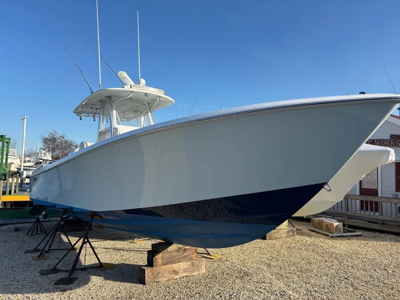Slide: The Image of 2015 Contender 35 ST on stands, featuring a blue hull and T-top, displayed outdoors. - 9