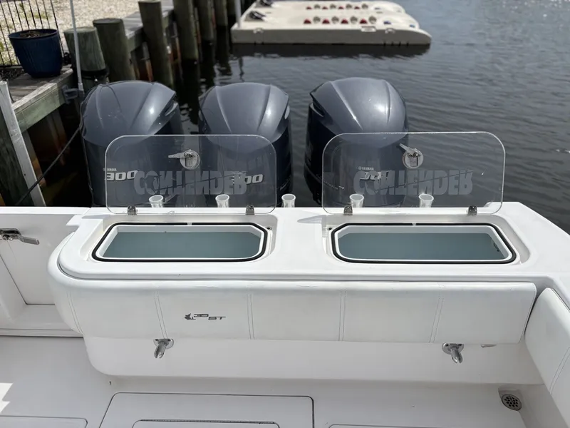Slide: The Image of The image shows the stern of a 2015 Contender 35 ST boat with three outboard engines and two livewells. - 5
