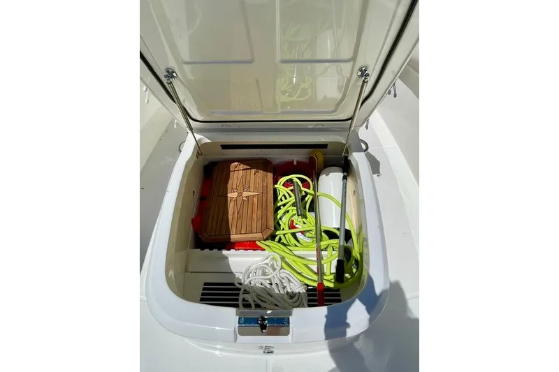 Slide: The Image of Storage compartment of 2025 Boston Whaler 330 Outrage with ropes and equipment. - 17
