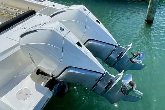 Slide: The Image of Twin outboard engines on a 2025 Boston Whaler 330 Outrage in clear water. - 21