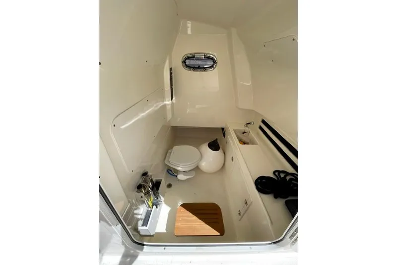 Slide: The Image of Interior of 2025 Boston Whaler 330 Outrage boat, featuring a compact marine toilet. - 14