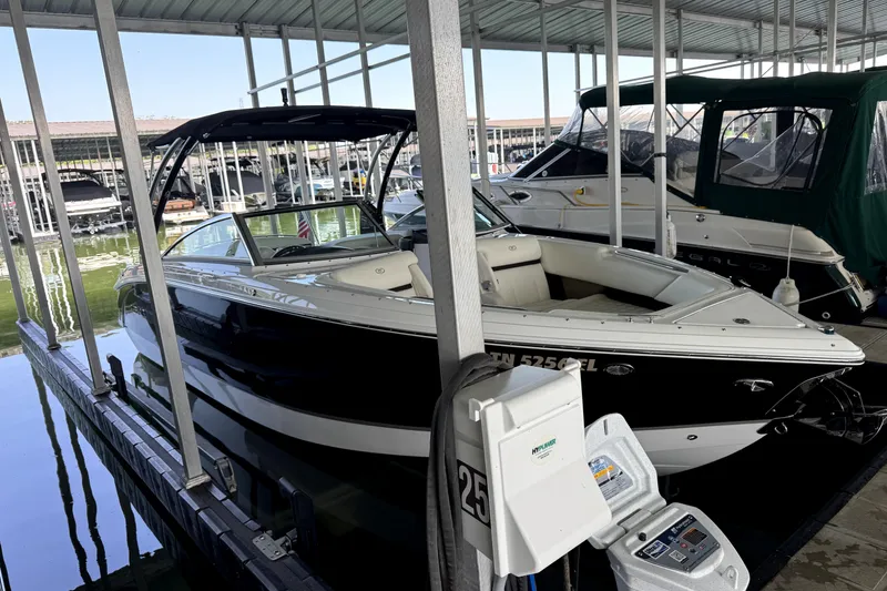 Slide: The Image of 2019 Cobalt R7 boat docked in a marina, featuring sleek black and white design. - 2