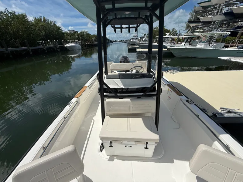 Slide: The Image of The image shows a 2027 Boston Whaler 210 Montauk boat docked in a calm marina. - 12