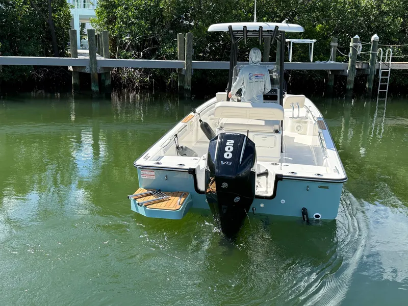 Slide: The Image of A 2027 Boston Whaler 210 Montauk in the water, featuring an outboard motor and open deck. - 7
