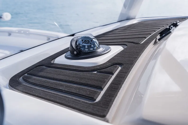 Slide: The Image of Close-up of a compass on the dashboard of a 2027 Boston Whaler 220 Dauntless. - 30