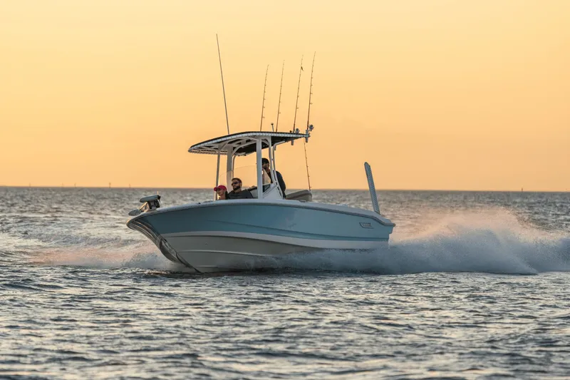 Slide: The Image of A Boston Whaler 220 Dauntless boat speeds across the water at sunset. - 11