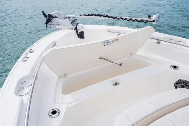 Slide: The Image of The image shows the bow of a Boston Whaler 220 Dauntless with an open storage compartment and a MotorGuide motor. - 38