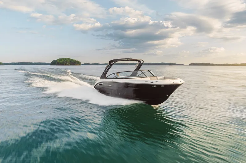Slide: The Image of 2025 Sea Ray SDX 250 cruising on calm water under a cloudy sky. - 92