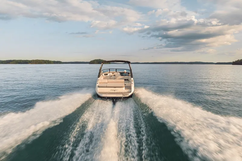Slide: The Image of 2025 Sea Ray SDX 250 speeding across calm water under a cloudy sky. - 93