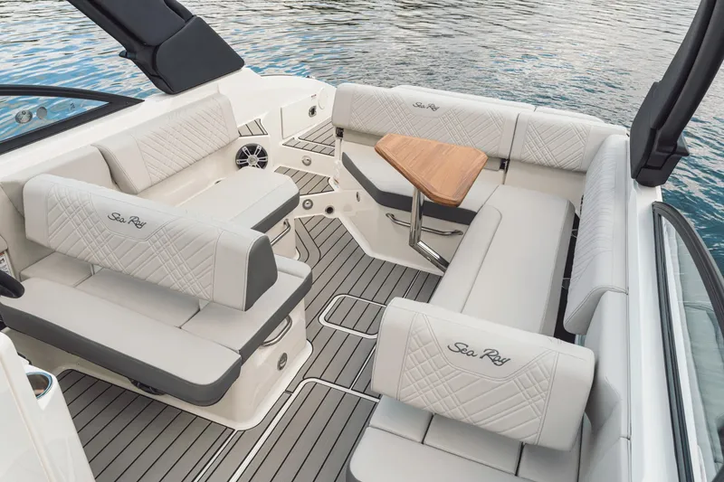 Slide: The Image of The image shows the cockpit of a 2025 Sea Ray SDX 250 with elegant white upholstery and a wooden table. - 42