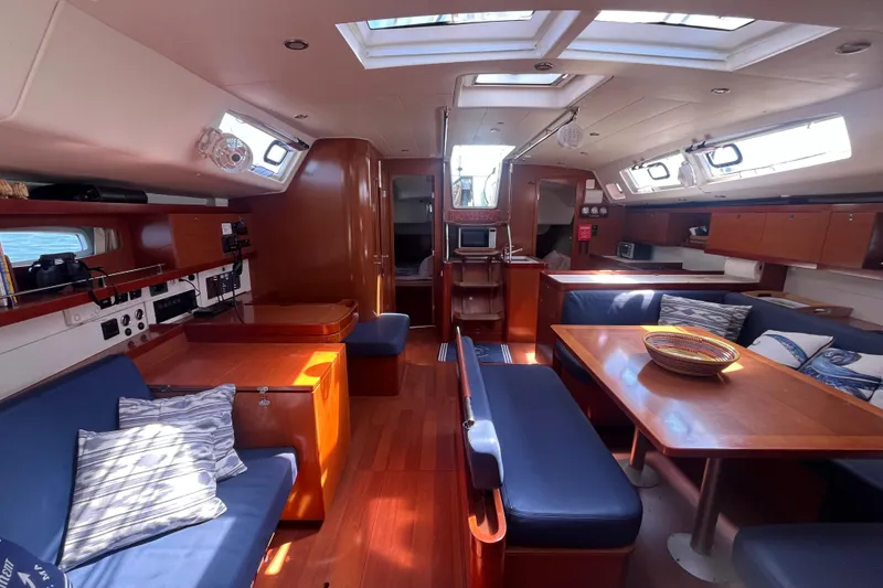 Slide: The Image of Interior of 2011 Beneteau Oceanis 54 yacht, featuring spacious seating and elegant wood finishes. - 34