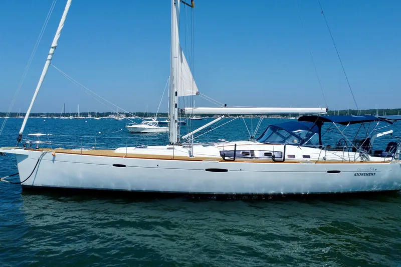 Slide: The Image of 2011 Beneteau Oceanis 54 sailboat on calm water under clear blue sky. - 2