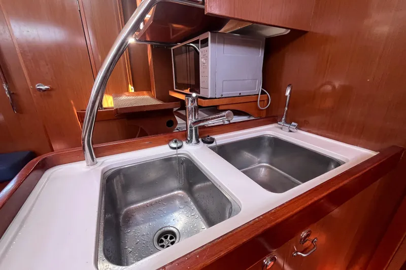 Slide: The Image of Galley kitchen in 2011 Beneteau Oceanis 54 yacht with double sink and microwave. - 29