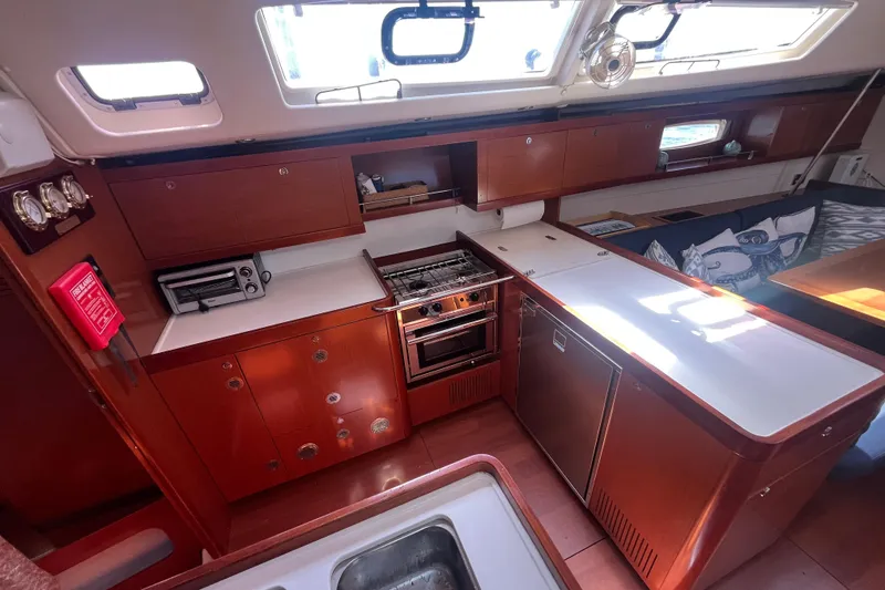 Slide: The Image of Interior of 2011 Beneteau Oceanis 54 yacht kitchen with wooden cabinetry and modern appliances. - 25