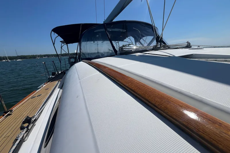 Slide: The Image of 2011 Beneteau Oceanis 54 sailboat deck with wooden accents, docked on a sunny day. - 22