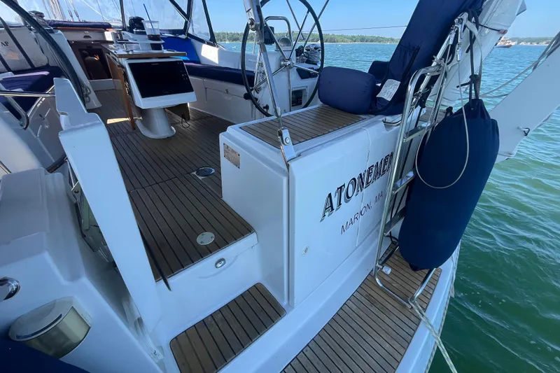 Slide: The Image of 2011 Beneteau Oceanis 54 yacht deck with wooden flooring and seating area. - 10