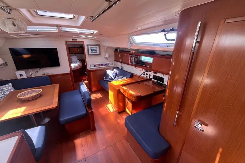 Slide: The Image of Interior of 2011 Beneteau Oceanis 54 yacht with wood finish and blue seating. - 24