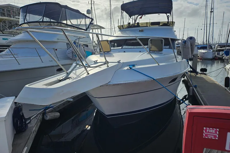 Slide: The Image of 1988 Silverton 37 Motor Yacht docked at marina, surrounded by other boats. - 3