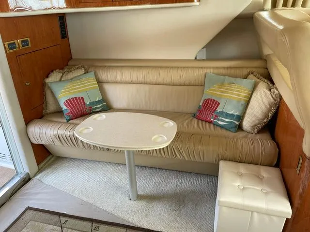 Slide: The Image of Interior of a 2001 Sea Ray 400 Sedan Bridge with beige sofa and decorative pillows. - 16