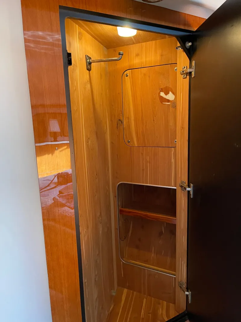 Slide: The Image of A wooden shower cabin with a glass door and towel rack inside a yacht. - 13