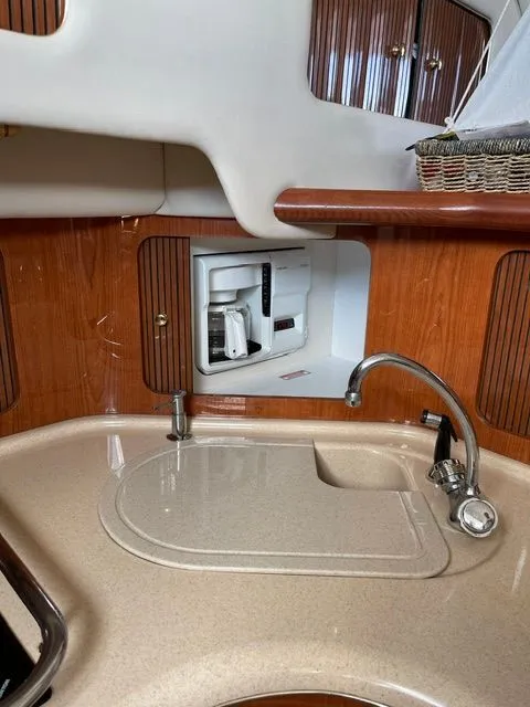 Slide: The Image of The 2001 Sea Ray 400 Sedan Bridge galley features a sink and built-in coffee maker. - 20