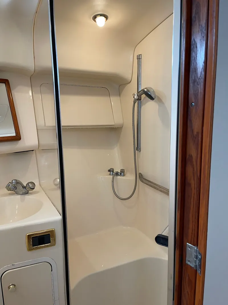 Slide: The Image of Bathroom in a 2001 Sea Ray 400 Sedan Bridge with shower, sink, and mirror. - 9