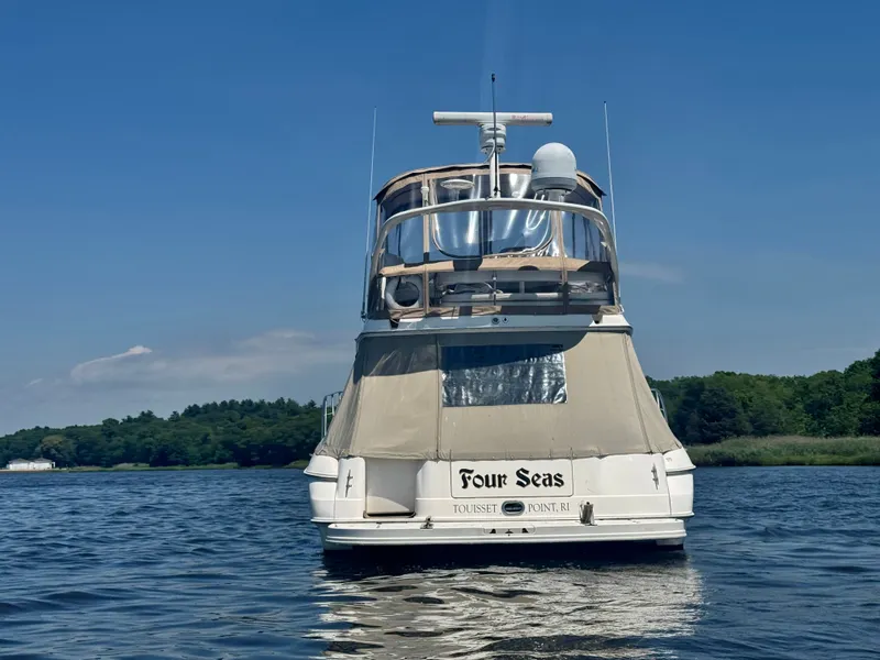 Slide: The Image of A 2001 Sea Ray 400 Sedan Bridge on calm water, featuring a covered upper deck. - 7