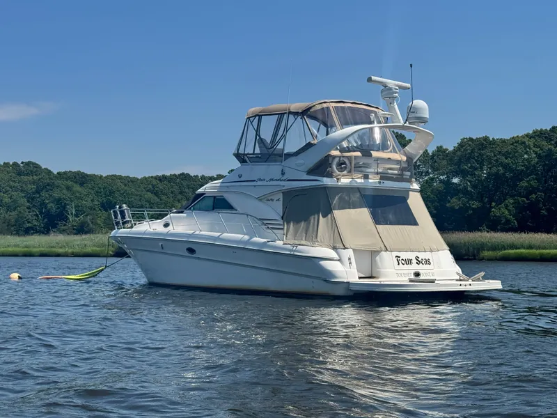 Slide: The Image of 2001 Sea Ray 400 Sedan Bridge on calm water, surrounded by green landscape. - 6