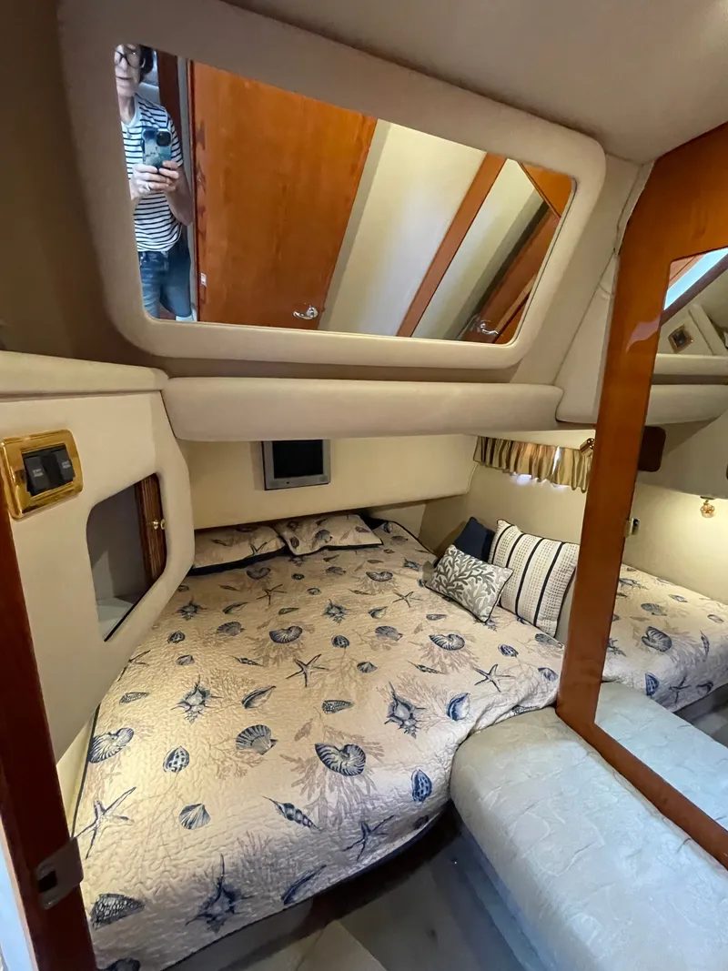 Slide: The Image of Cabin of the 2001 Sea Ray 400 Sedan Bridge with a cozy bed and mirror. - 12