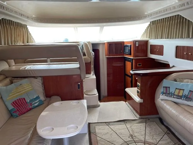 Slide: The Image of Interior of a 2001 Sea Ray 400 Sedan Bridge with cozy seating and wooden cabinetry. - 12
