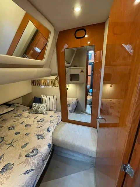 Slide: The Image of Interior of a 2001 Sea Ray 400 Sedan Bridge featuring a cozy bedroom and mirror. - 17