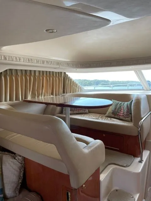 Slide: The Image of Interior of a 2001 Sea Ray 400 Sedan Bridge with beige sofa and wooden table. - 15