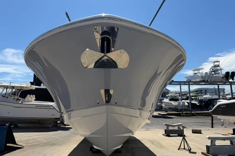 Slide: The Image of 2023 Robalo R360 Center Console boat in marina, showcasing sleek hull design. - 3