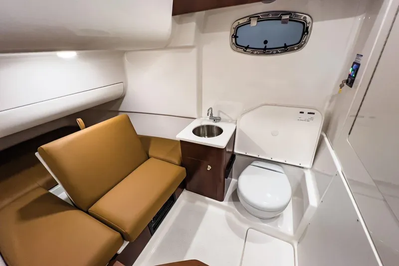 Slide: The Image of 2023 Robalo R360 Center Console cabin with sink, toilet, and seating area. - 47