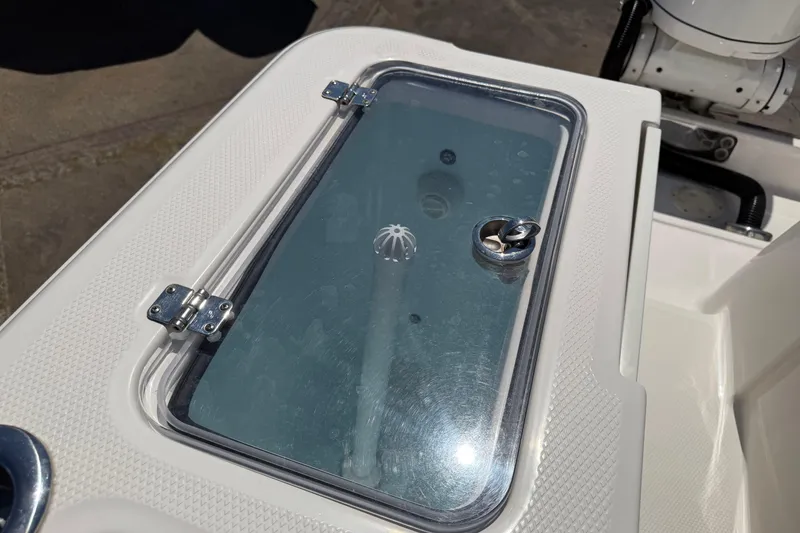 Slide: The Image of 2023 Robalo R360 Center Console boat hatch with secure latch and textured surface. - 10
