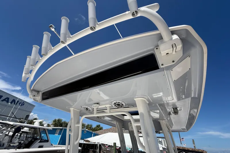 Slide: The Image of 2023 Robalo R360 Center Console boat with rod holders and speakers under a clear blue sky. - 16