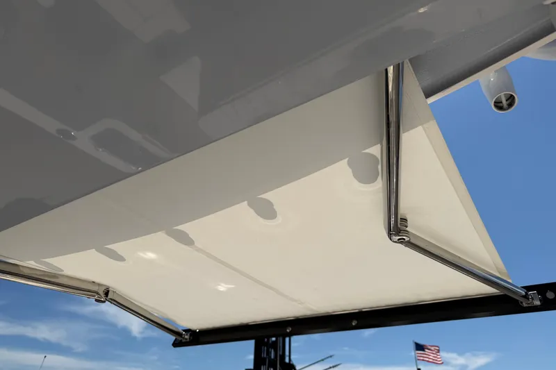 Slide: The Image of 2023 Robalo R360 Center Console boat canopy detail with clear blue sky background. - 24